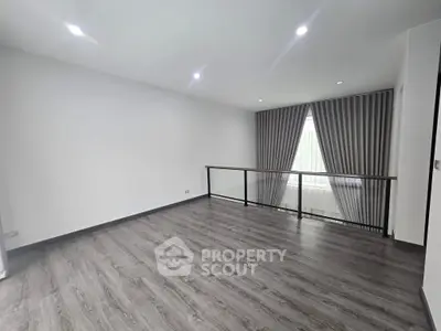 Spacious modern living room with elegant flooring and large window with curtains.