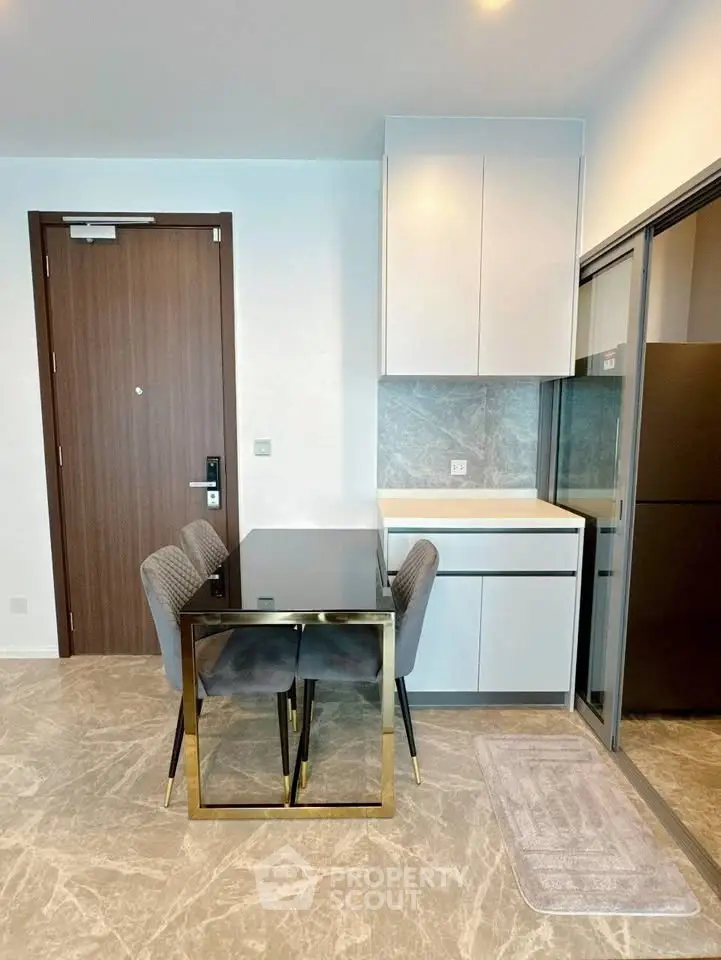 Modern kitchen with sleek design, featuring a compact dining area and stylish cabinetry.
