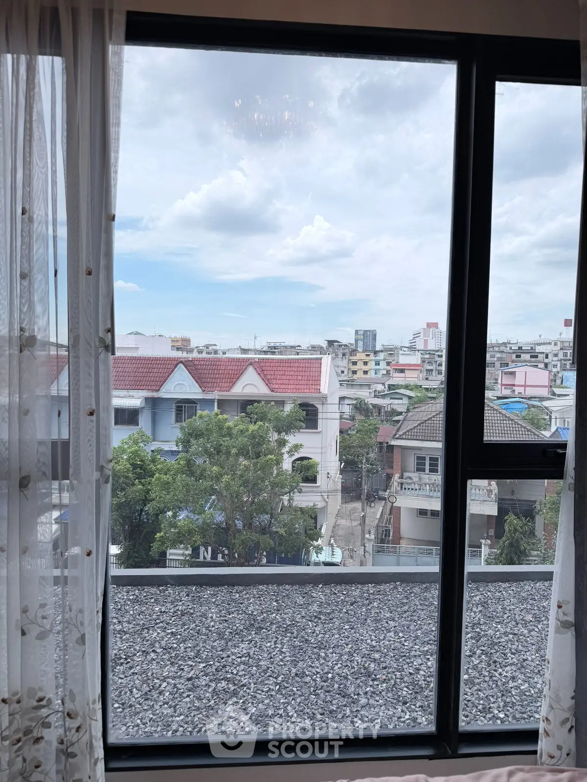Stunning cityscape view from a modern apartment window, showcasing urban living with a touch of tranquility.