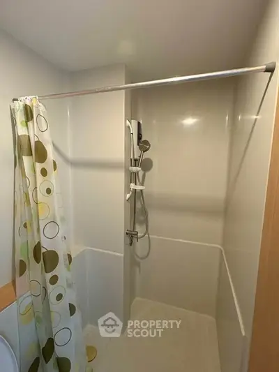 Compact bathroom with shower and modern curtain in a cozy apartment.