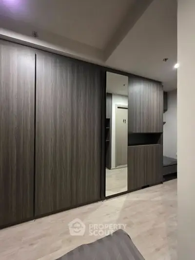 Modern bedroom with sleek built-in wardrobe and mirror