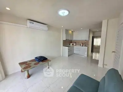 Spacious open-plan living area with modern kitchen and minimalist decor.