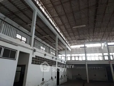 Spacious industrial warehouse with high ceilings and ample natural light.