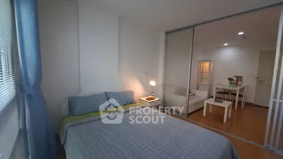 Cozy bedroom with sliding glass doors leading to a modern living area, perfect for urban living.