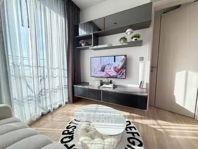 Modern living room with sleek furniture and large windows offering natural light.