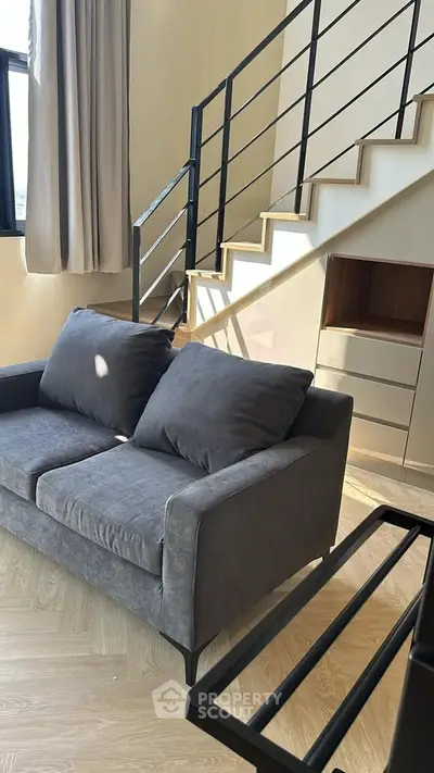 Modern loft living room with stylish staircase and cozy gray sofa