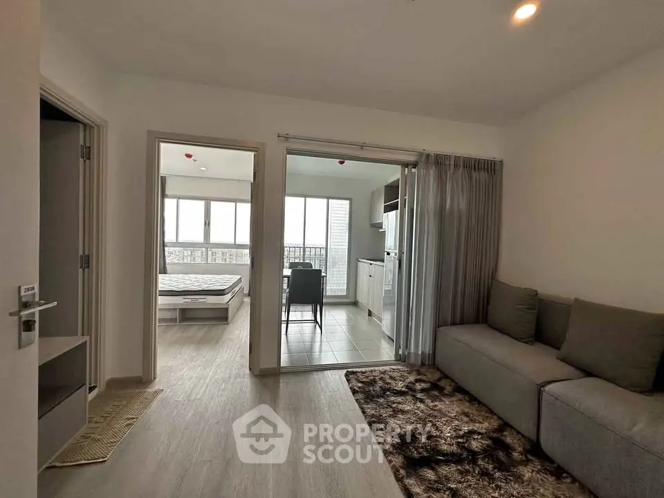 Modern apartment interior with cozy living room, bedroom, and open kitchen layout.