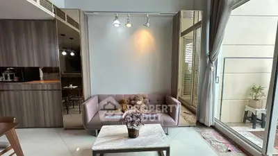 Chic living room with plush sofa, elegant decor, and large windows opening to a balcony.