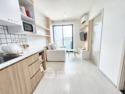 Modern living room with open kitchen, sleek design, and balcony view in a stylish apartment.