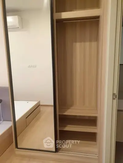 Modern bedroom with mirrored wardrobe and wooden flooring