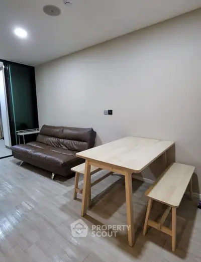 Modern living room with sleek brown sofa and minimalist wooden dining set