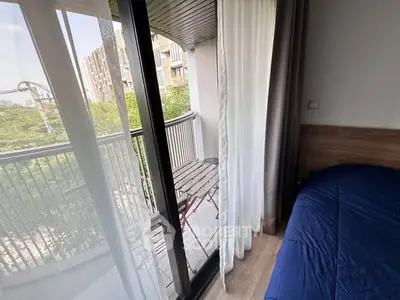 Cozy bedroom with balcony access and city view, perfect for urban living.