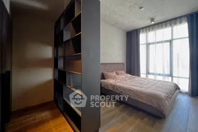 Modern bedroom with large window and stylish shelving unit, featuring elegant decor and natural light.