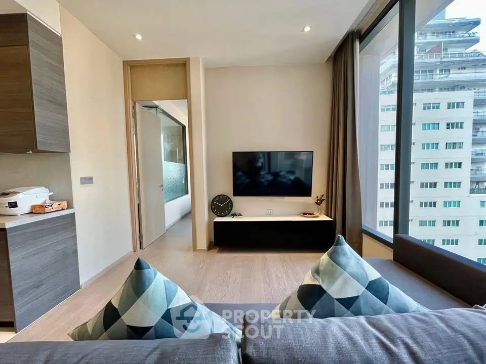 Modern living room with stylish decor and large windows offering city views