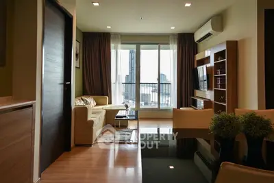 Modern living room with city view, featuring sleek furniture and large windows for natural light.