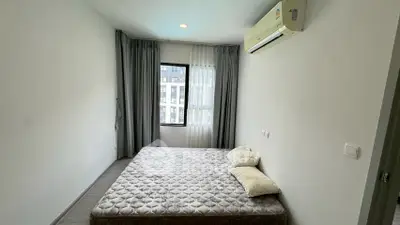 Cozy bedroom with large window and air conditioning in modern apartment
