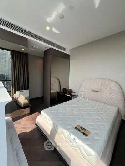 Modern bedroom with large mirror and natural light in urban apartment