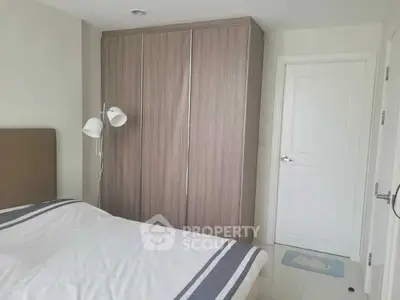 Modern bedroom with sleek wardrobe and cozy bed in a minimalist design.