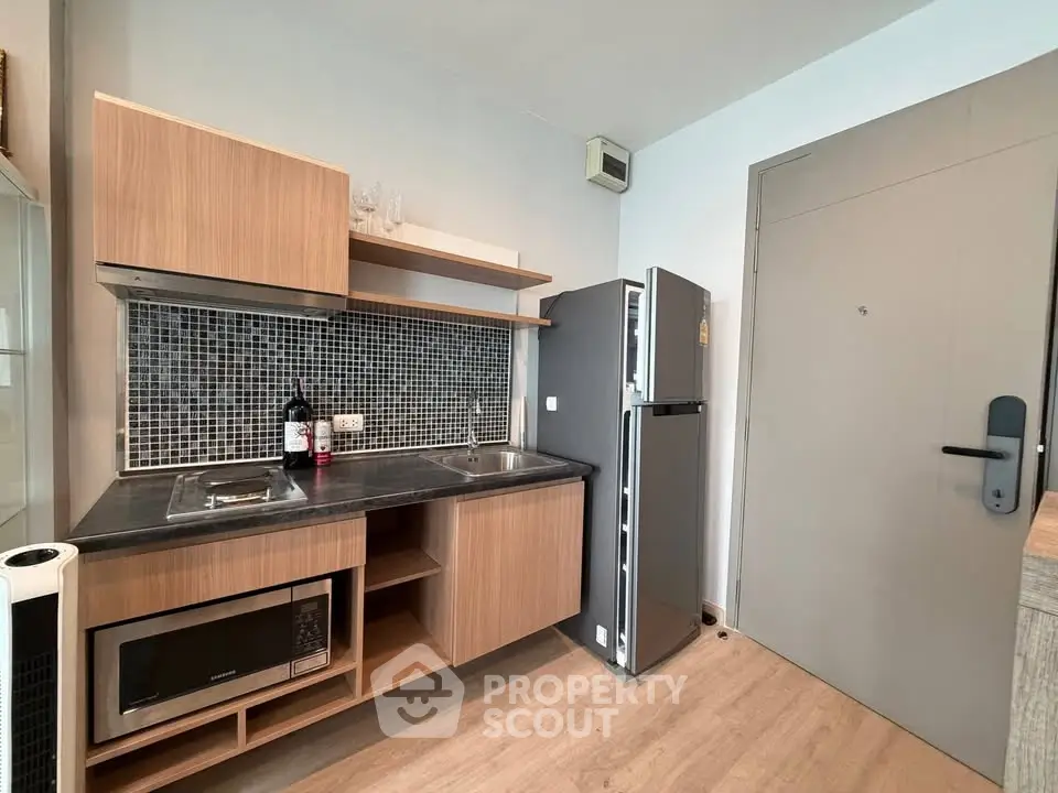 Modern compact kitchen with sleek appliances and wooden cabinetry