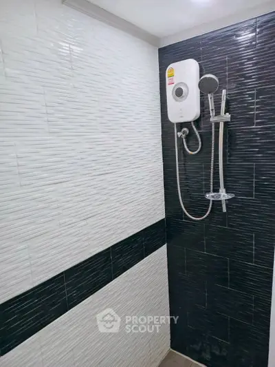 Modern bathroom shower with sleek black and white tile design