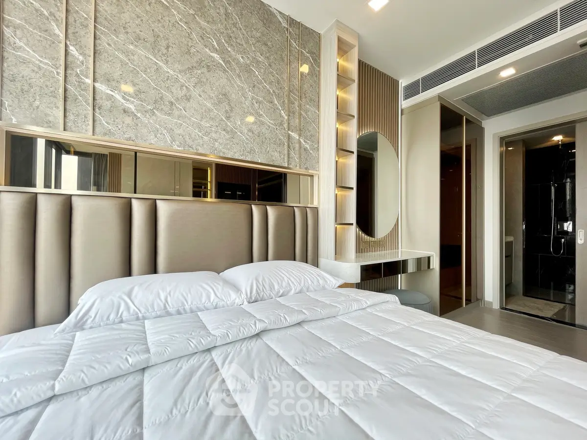 Luxurious modern bedroom with elegant decor and ensuite bathroom in a high-end apartment.