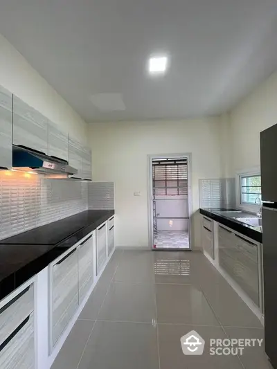 Modern kitchen with sleek cabinetry and glossy tile flooring