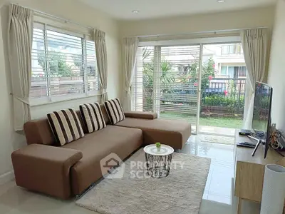 Modern living room with stylish sofa and garden view, perfect for relaxation and entertaining.