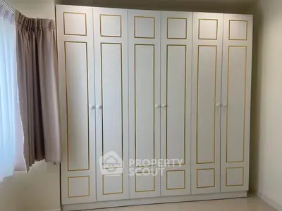 Spacious bedroom with elegant built-in wardrobe and natural light