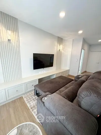 Modern living room with sleek TV setup and cozy seating area