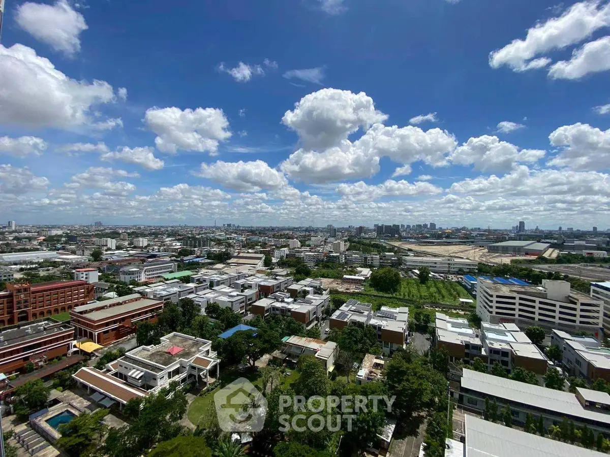 Stunning aerial view of urban landscape with lush greenery and vibrant cityscape under a clear blue sky.