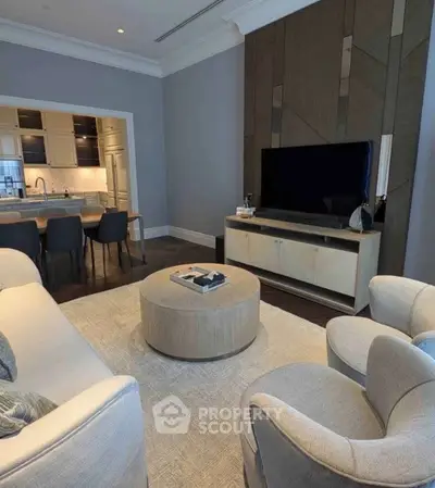 Luxurious living room with modern furniture and open kitchen layout, perfect for entertaining.