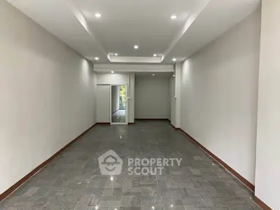 Spacious unfurnished room with modern lighting and tiled flooring, ideal for customization.