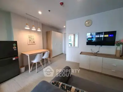 Modern living room with stylish decor and wall-mounted TV in a cozy apartment.