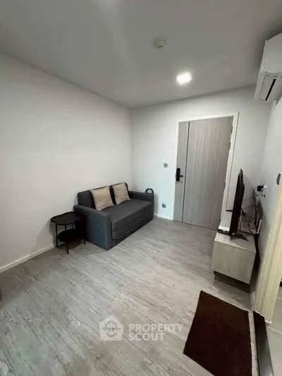 Modern living room with sleek design, featuring a cozy sofa and flat-screen TV, perfect for relaxation.