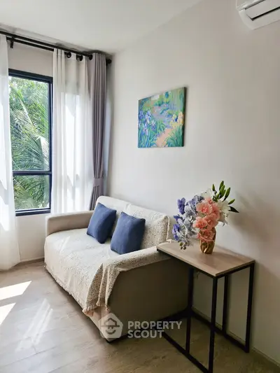 Charming living room with cozy sofa, elegant decor, and natural light from large window.