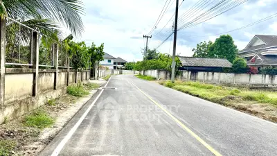 Charming suburban street view with houses and lush greenery, perfect for tranquil living.
