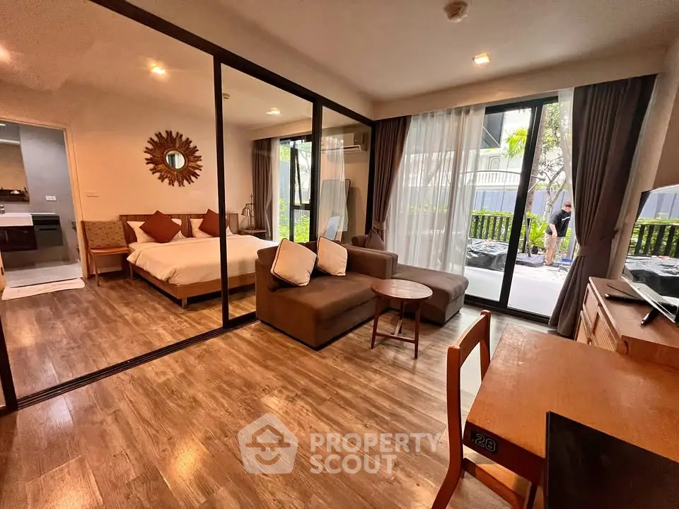 Modern studio apartment with open layout and poolside view, featuring stylish decor and natural light.