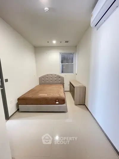 Minimalist bedroom with modern bed and air conditioning unit, perfect for cozy living.