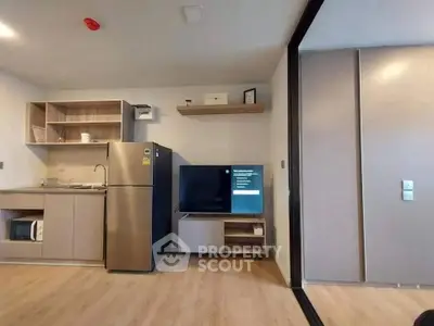 Modern kitchen with stainless steel fridge and sleek cabinetry in open layout.