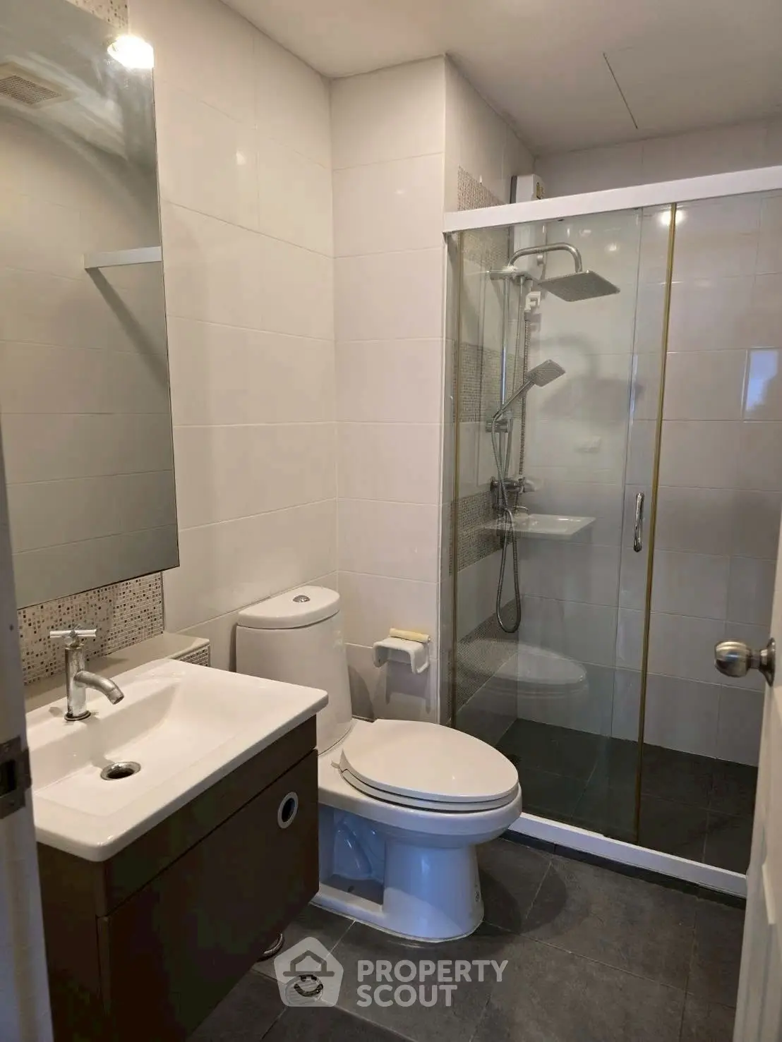 Modern bathroom with glass shower, sleek vanity, and contemporary fixtures.