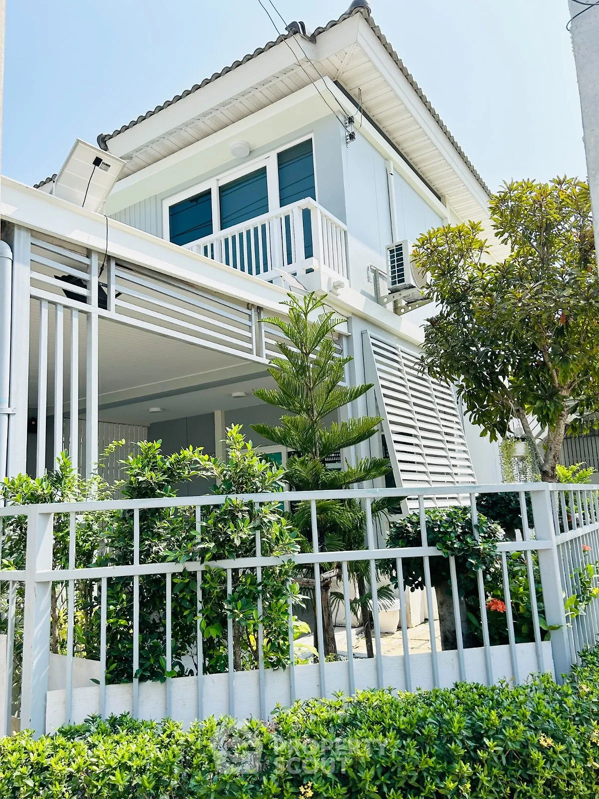Charming modern two-story house with lush garden and balcony in a serene neighborhood.