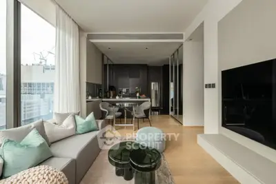 Modern living room with open kitchen and city view, featuring stylish furniture and decor.