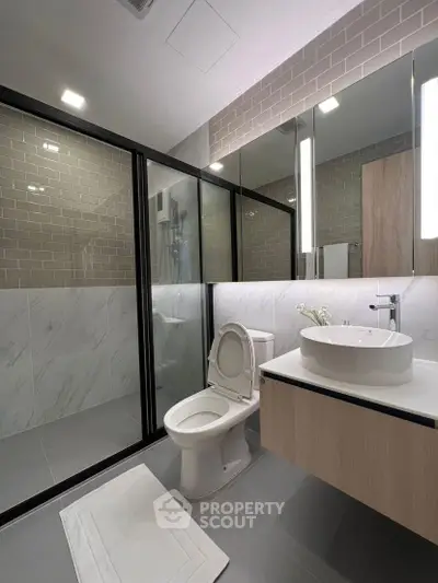 Modern bathroom with sleek design, featuring glass shower enclosure and stylish vanity.