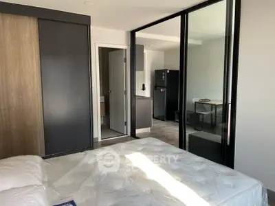 Modern bedroom with sliding glass doors and sleek kitchen view