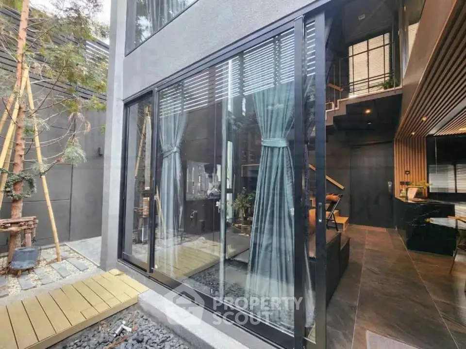 Modern luxury home exterior with large glass windows and stylish interior view.