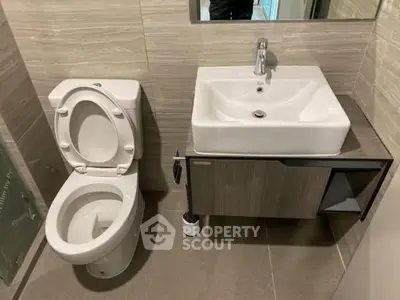 Modern bathroom with sleek sink and toilet in neutral tones