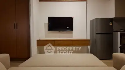 Modern living room with wall-mounted TV and sleek refrigerator