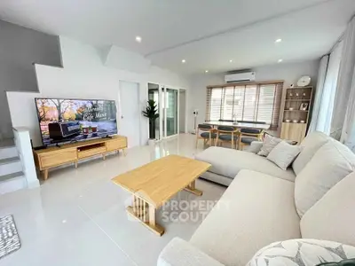 Spacious modern living room with cozy sofa and large TV, perfect for relaxation and entertainment.