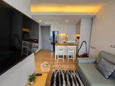 Modern living room with open kitchen, stylish decor, and cozy seating area in a contemporary apartment.