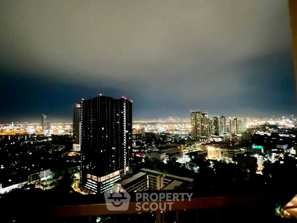 Stunning cityscape view from high-rise balcony at night with illuminated skyline.